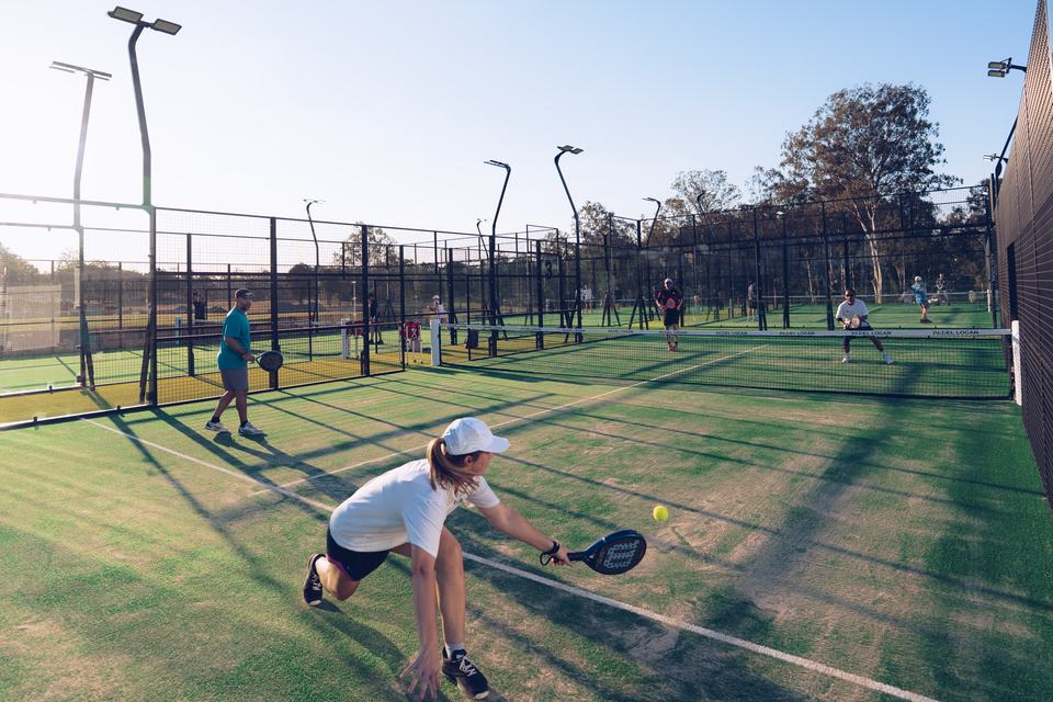 A player returning a shot on court at Padel Logan